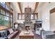 Elegant living room featuring a stone fireplace, exposed wood beams, and large windows with stunning mountain scenery at 805 Highfield Trl, Breckenridge, CO 80424