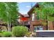 Multi-level back exterior featuring a deck, stairs, hot tub, and wood siding at 805 Highfield Trl, Breckenridge, CO 80424