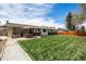 Spacious backyard featuring a stone patio with outdoor dining, a lush lawn, and privacy fencing at 7960 Estes Ct, Arvada, CO 80005