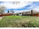 Expansive backyard features lush green lawn, a stone patio with outdoor seating, and privacy fence at 7960 Estes Ct, Arvada, CO 80005