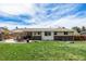 Large, well-maintained backyard with stone patio, dining set, lush lawn, and mature trees at 7960 Estes Ct, Arvada, CO 80005