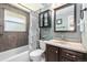 Bathroom featuring a tiled shower and tub, vanity with mirror, and black accent storage at 7960 Estes Ct, Arvada, CO 80005