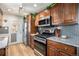 Well-equipped kitchen with stainless steel appliances, warm wooden cabinets, granite countertops, and a view to the outside at 7960 Estes Ct, Arvada, CO 80005