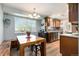 Inviting kitchen features warm wood cabinetry, modern appliances, and an adjacent dining area with natural light streaming through the window at 7960 Estes Ct, Arvada, CO 80005