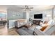 Open living room offers wood floors, a ceiling fan, comfortable seating, and a cozy fireplace for relaxing entertainment at 7960 Estes Ct, Arvada, CO 80005
