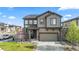 Two-story home features a front yard with green grass, an attached two-car garage and solar panels at 2688 Loon Cir, Castle Rock, CO 80104