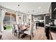 Modern kitchen and dining area with dark cabinets, stainless steel appliances, and a large dining table at 2688 Loon Cir, Castle Rock, CO 80104