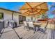 A wooden deck with an outdoor dining set is shaded by a large umbrella, creating an ideal spot for relaxation at 3680 S Glencoe St, Denver, CO 80237