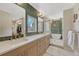 A well-lit bathroom with wooden cabinets, double sinks, and a shower at 3680 S Glencoe St, Denver, CO 80237