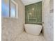 Modern bathroom featuring a freestanding tub, hexagon tile floor, and green tile accent wall at 3680 S Glencoe St, Denver, CO 80237