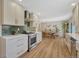 Open kitchen overlooking dining area featuring stainless steel appliances and white cabinets at 3680 S Glencoe St, Denver, CO 80237