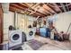 Unfinished basement with laundry machines, exposed ceiling, and storage shelves at 7217 Huron St, Denver, CO 80221