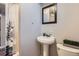 Small bathroom featuring a pedestal sink, framed mirror and shower with floral shower curtain at 7217 Huron St, Denver, CO 80221