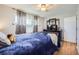 Bedroom featuring hardwood floors, a ceiling fan, a bed with blue comforter, and a dresser with tv at 7217 Huron St, Denver, CO 80221