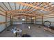 Inside of a metal barn with wooden rafters, concrete floor, and side door at 40477 Ferns Rd, Elizabeth, CO 80107