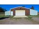 A large barn with a brown and white facade, and a large garage door in a green field at 40477 Ferns Rd, Elizabeth, CO 80107