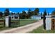 View of the entrance gate leading to the home with lush greenery and trees surrounding the property at 40477 Ferns Rd, Elizabeth, CO 80107