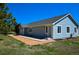Back exterior of light blue ranch home featuring a brick patio and view of landscaping at 40477 Ferns Rd, Elizabeth, CO 80107