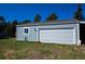 Detached garage with white garage door and single window. Includes side yard and landscaping at 40477 Ferns Rd, Elizabeth, CO 80107