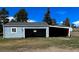 A detached light blue garage with an open bay and covered parking on a grassy lot at 40477 Ferns Rd, Elizabeth, CO 80107