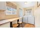 Convenient laundry area with washer, dryer, counter space, and natural light at 1030 Krameria St, Denver, CO 80220