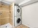 Basement bathroom features a tiled shower and stacked washer and dryer for convenience at 1615 S Elizabeth St, Denver, CO 80210