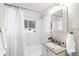 Bright bathroom with white tiled walls, shower-tub combo, and a vanity with countertop at 1615 S Elizabeth St, Denver, CO 80210