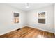 Sun-filled bedroom with hardwood floors, white walls, and dual windows provide natural light at 1615 S Elizabeth St, Denver, CO 80210
