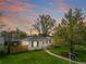 Charming single-story home with a well-maintained lawn and mature trees against a picturesque sunset backdrop at 1615 S Elizabeth St, Denver, CO 80210