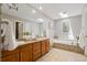 Beautiful bathroom with dual sinks, granite countertops, and luxurious soaking tub at 11453 E Orchard Pl, Englewood, CO 80111