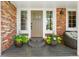 Charming front door with brick accents and decorative flower pots, creating an inviting entrance at 11453 E Orchard Pl, Englewood, CO 80111