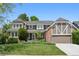 Charming two-story home boasts a landscaped yard and inviting curb appeal with well-manicured lawn and mature plantings at 11453 E Orchard Pl, Englewood, CO 80111