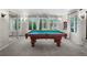 Well lit game room with pool table, plush carpet, and large windows overlooking the outdoor greenery at 11453 E Orchard Pl, Englewood, CO 80111