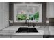 Modern kitchen sink with granite countertops and a view of the backyard at 11453 E Orchard Pl, Englewood, CO 80111