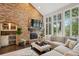 Comfortable living room featuring a brick fireplace, built-in bar, and large windows with scenic views, ideal for relaxation at 11453 E Orchard Pl, Englewood, CO 80111