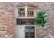 Elegant wine cellar with brick surround, wine fridge, and storage at 11453 E Orchard Pl, Englewood, CO 80111