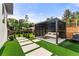 Backyard featuring a modern pergola with a seating area, landscaped with pavers and artificial turf at 220 Glencoe St, Denver, CO 80220