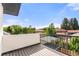 Spacious deck with black metal railing and beautiful views of the surrounding trees and neighborhood at 220 Glencoe St, Denver, CO 80220
