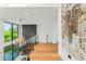 Upstairs landing with elegant chandelier, glass railing, and view of the fireplace below at 220 Glencoe St, Denver, CO 80220