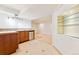 Basement bar area with cabinetry, mini fridge, and tiled backsplash at 2412 Windmill Dr, Longmont, CO 80504