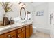 Bathroom showcasing a tub, vanity with sink, decorative tile, and an oval mirror at 2412 Windmill Dr, Longmont, CO 80504