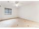 Bedroom features neutral colors, modern ceiling fan, a large window with covering, and ceramic tile flooring at 2412 Windmill Dr, Longmont, CO 80504