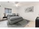 Bedroom features neutral colors, modern ceiling fan, and a large window with covering at 2412 Windmill Dr, Longmont, CO 80504