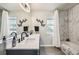 Chic bathroom featuring dual sinks, marble countertop, tub and shower combination, and butterfly wall decor at 1492 Red Cliff Way, Castle Rock, CO 80109