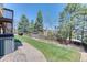 Sloped backyard with a concrete patio, privacy fence, and mature trees at 58 Rogers Ct, Golden, CO 80401
