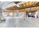 Unfinished basement with exposed ceiling beams, structural poles and door to the backyard is ready for customization at 58 Rogers Ct, Golden, CO 80401