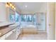 Bright bathroom with a bathtub, a glass-enclosed shower, double sinks, and ample natural light at 58 Rogers Ct, Golden, CO 80401
