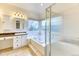 Bright bathroom with a bathtub, a glass-enclosed shower, double sinks, and ample natural light at 58 Rogers Ct, Golden, CO 80401