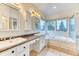 Bathroom featuring double sinks, vanity lighting, a large window view and a shower behind a glass partition at 58 Rogers Ct, Golden, CO 80401