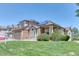 Charming two-story home featuring a manicured lawn, mature landscaping, and solar panels on the roof at 58 Rogers Ct, Golden, CO 80401